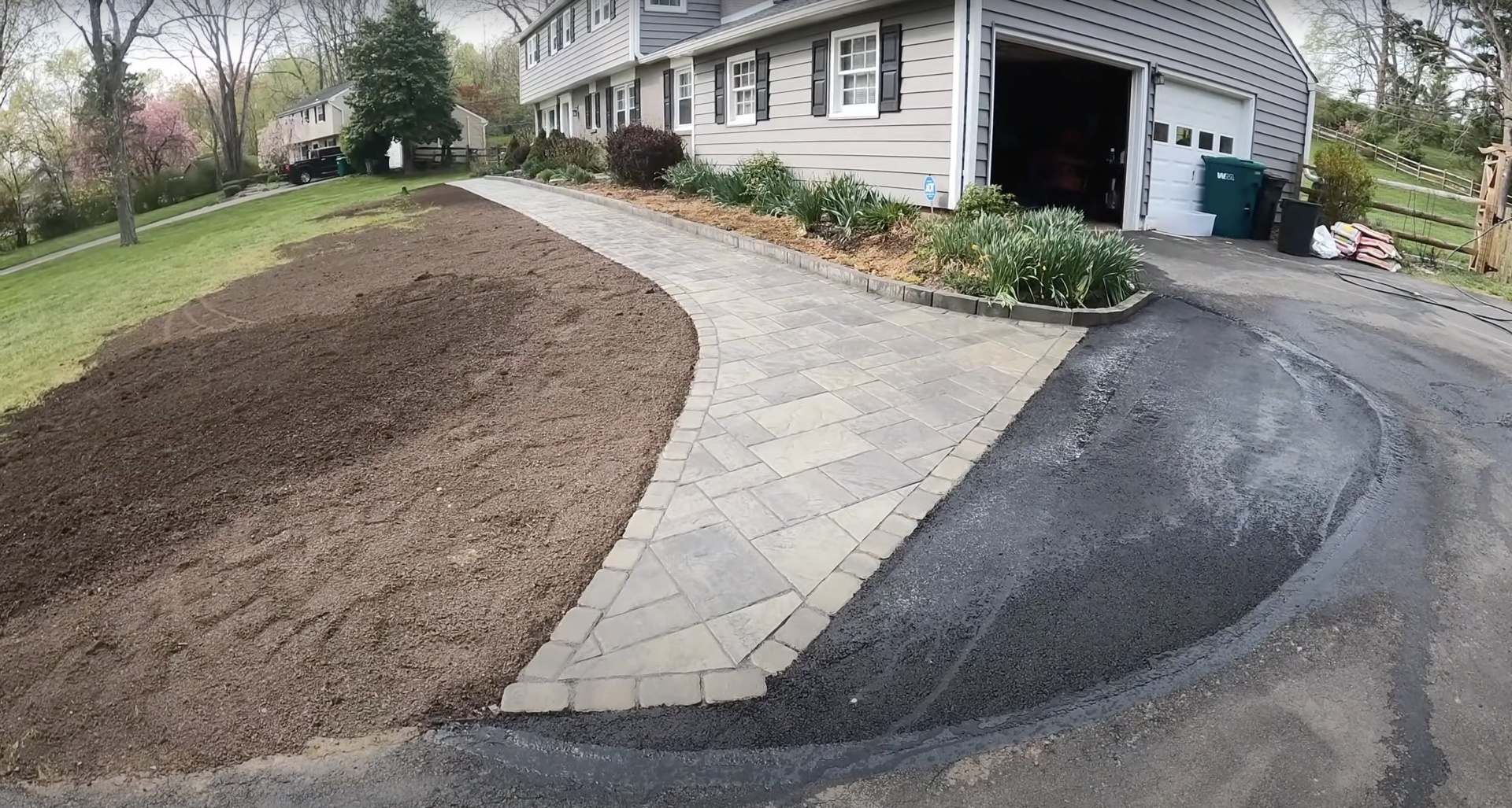 Gary Concrete - Decorative concrete driveway with paver accent installation Residential driveway installation showing decorative concrete pavers and professional landscaping